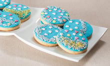 Biscotti decorati con pasta di zucchero azzurri adagiati su un piatto bianco