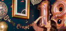 Una ragazza che guarda i palloncini Rose Gold a forma di numero 18