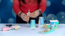 Le mani di una persona che realizzano delle decorazioni per una festa a tema