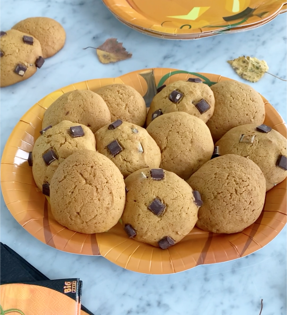 Un piatto di biscotti di zucca con gocce di cioccolato preparati per Halloween