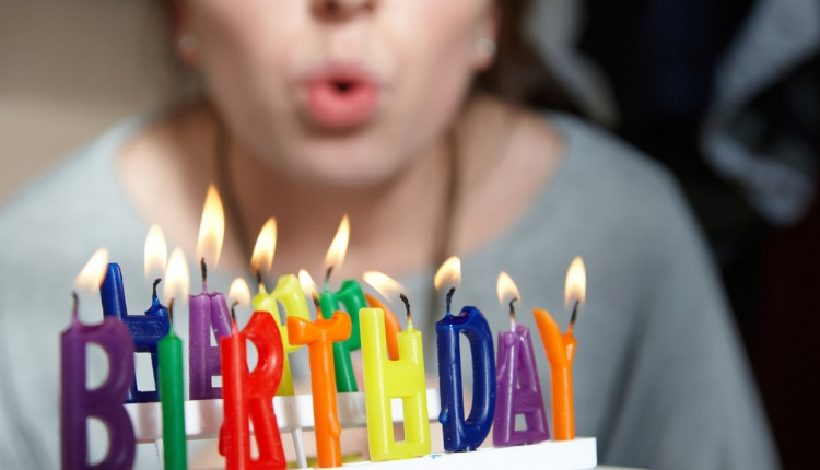 Bambina che soffia sulle candeline di compleanno