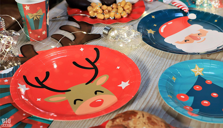 Piatti con decorazioni natalizie (come la faccia di una renna) sopra una tavola decorata per Natale