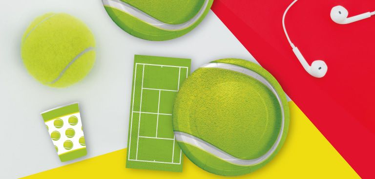 Articoli da festa a tema tennis, inclusi piatti e bicchieri decorati con motivi di palline da tennis e campi da gioco, su sfondi colorati in verde, giallo e rosso.